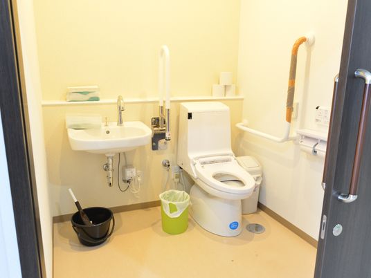 明るい色を基調とした広々としたトイレ。車椅子をご利用の方の移動もスムーズなスペースのトイレ内には手洗いが設置されている。