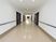 ベージュの床、白い壁が明るい雰囲気の広々としたスペースがある直線の長い廊下。手すりが設置されている。