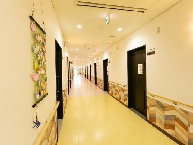 廊下の壁面に飾り付け 廊下 廊下には、手作りの装飾が壁に飾られており、温かみのある雰囲気です。床は滑りにくい素材で安全に配慮されています。