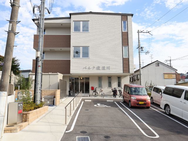 新しい建物の外観 外観 清潔感あふれる新築の建物は、落ち着いた色合いと広々とした駐車スペースが印象的です。アクセスしやすい立地で、快適な職場環境を求める方に最適です。