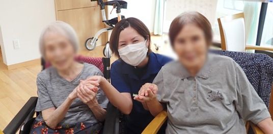 笑顔で触れ合うスタッフと居住者