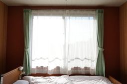 明るい部屋のベッドと窓