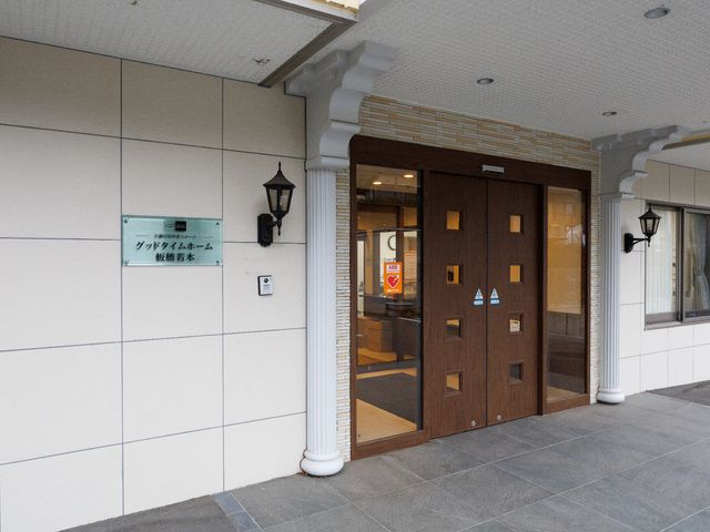 エレガントな施設のエントランス 玄関 落ち着いた色合いのエントランスは、シックで心地よい第一歩をご提供します。安全な出入りのためのAEDも完備しております。