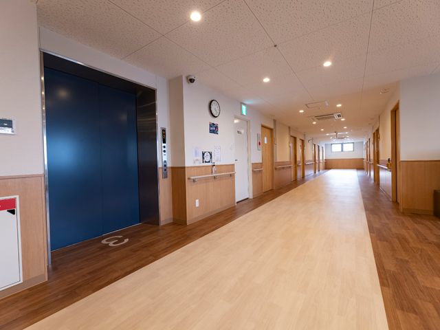 広々とした廊下の様子 エレベーター 明るい木目調の床が印象的な廊下は、清潔感があり、のびのびとお過ごしいただける空間です。
