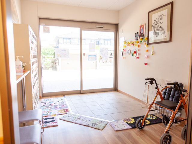 広々としたエントランス エントランス 床に敷かれたカラフルなマットが彩りを加えるエントランスです。車椅子を置くスペースも十分にあります。