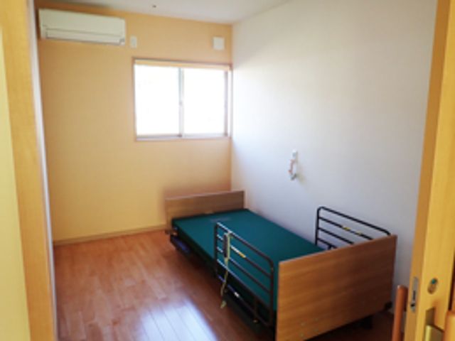 窓際の居室 居室 自然光が入る明るい居室で、穏やかな環境です。ベッドとエアコンが完備されています。