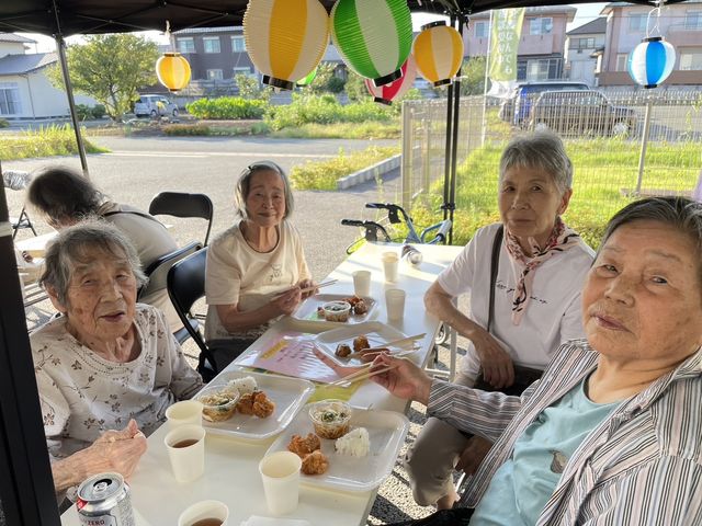 笑顔の高齢者たちの集い 多目的室 笑顔の高齢者たちが食事を楽しむ和やかな場です。交流が活発な雰囲気があります。