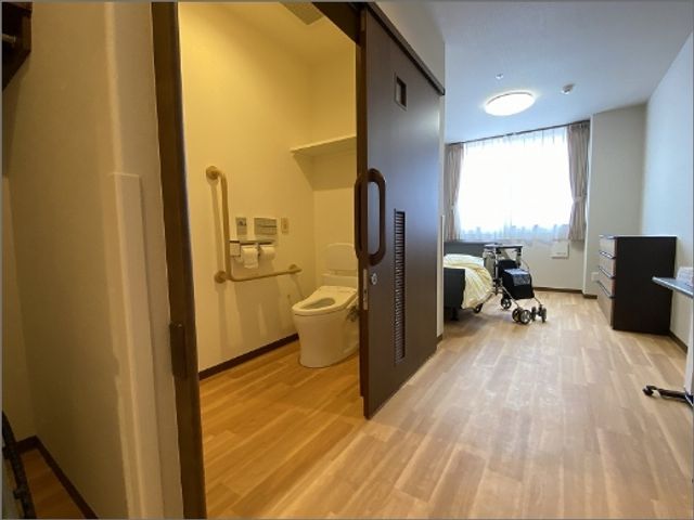 居室とトイレ 居室 明るい窓から自然光が差し込む居室には、快適なトイレが隣接されています。介護に適した広々とした空間です。
