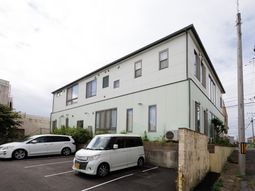 白と緑の外観の建物