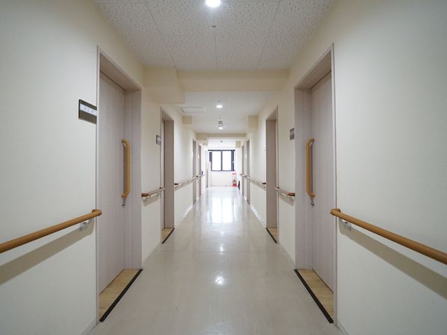 廊下の手すりとドア 廊下 すっきりとした廊下は手すりが付いており、日々の移動が安全にご利用いただけます。明るく落ち着いた雰囲気で、ゆったりとした時間を過ごせる空間です。