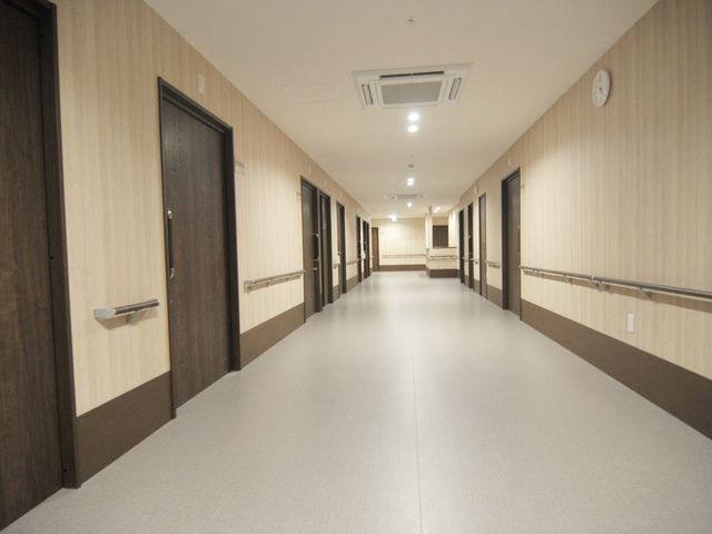 清潔な施設の廊下 立地 手すり付きで安全に配慮された廊下です。清掃が行き届いており、働く環境としても快適です。