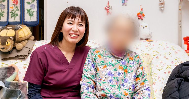 笑顔の女性と入居者が一緒にいる居室