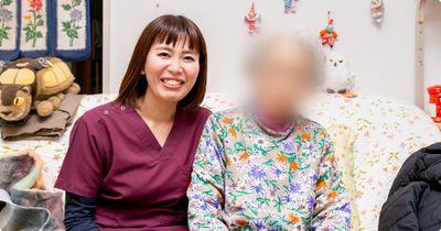 笑顔の女性と入居者が一緒にいる居室