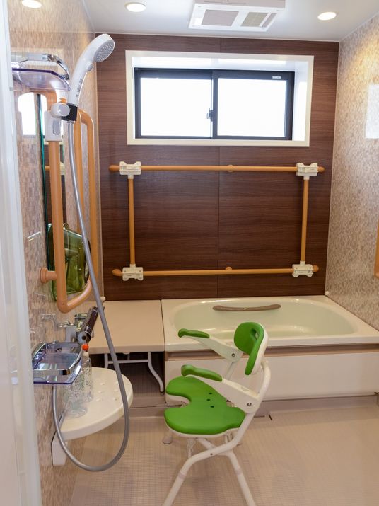 シャワーやシャワーチェアが付いた浴室には一人用の浴槽が設置され、ベンチや手すりが付いている。
