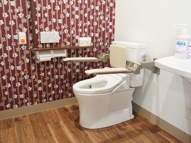 バリアフリー設計の洗面台 トイレ 手すり付きのトイレは安全に配慮され、使いやすさを考えた設計です。清潔感のある空間で快適にお過ごしいただけます。