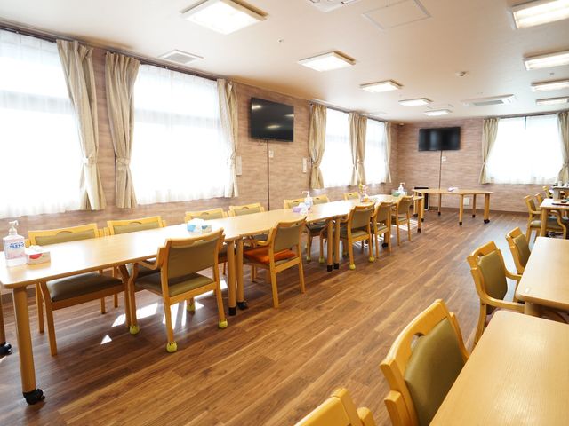 明るいダイニングルーム 共有スペース ゆとりある空間のダイニングで、共に食事の時間を過ごしませんか。広々とした窓から自然光が差し込み、居心地の良い環境です。