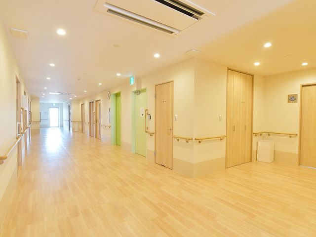 ゆったり廊下 廊下 木目調で温かみのある廊下は、明るく清潔感があり、歩行のサポートにも配慮されています。ゆとりを感じる広々とした空間が、快適な就業環境を提供します。