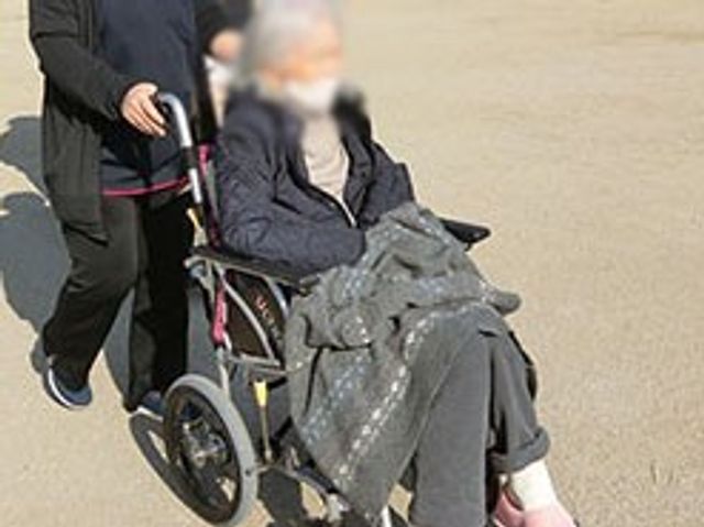 車椅子での外出 スタッフイメージ 介護スタッフが車椅子での外出をサポートしています。介護業務を学ぶ良い機会です。