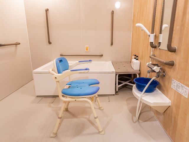 バリアフリー浴室設備 浴室 手すりとシャワーチェアを備えた安全な浴室です。利用者のケアを支援する環境が整っています。