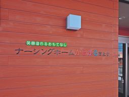 赤い壁と緑のロゴ看板