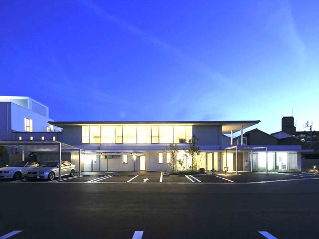 夕景の建物外観 外観   大きな窓から明かりが漏れる、開放感のある建物です。駐車スペースもあり、働く場としても出入りしやすそうです。