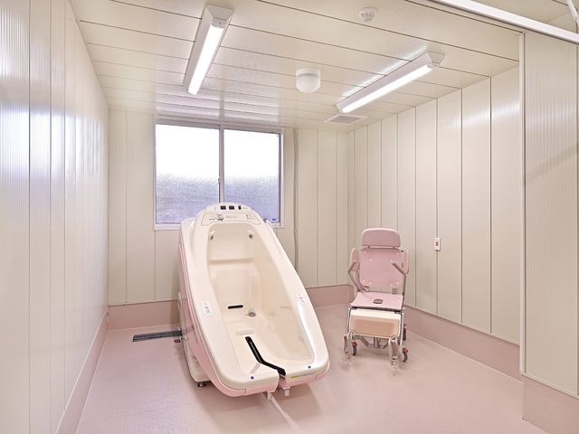 機械浴室 浴室   明るい空間に機械浴槽が設置されています。介助しやすい設備が整っており、安心感のある入浴支援が想像できます。