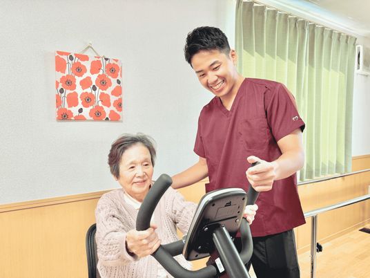 笑顔のスタッフと高齢者がトレーニング室
