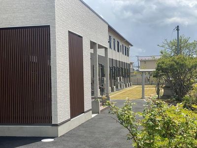 緑に囲まれた建物の外観  
