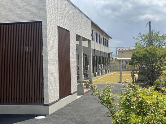 緑に囲まれた建物の外観  
