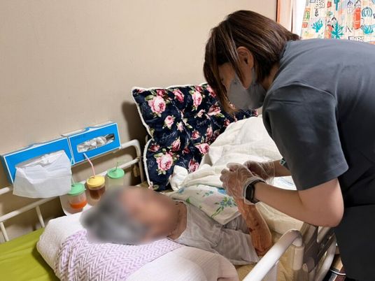 介護士が利用者を支える居室  