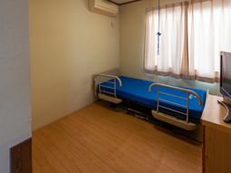 明るい居室のベッドと窓