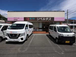 送迎車が並ぶ施設外観  