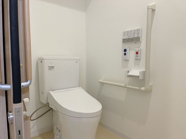 手すり付き清潔なトイレ トイレ 安全に配慮されたデザインのトイレです。手すりがあり、利用しやすくなっています。