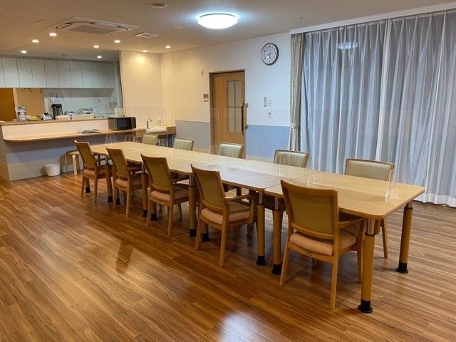 明るい食堂のテーブル席 食堂   木目調の床が広がる明るい食堂です。ゆったりしたテーブル配置で、落ち着いて食事や会話がしやすそうです。