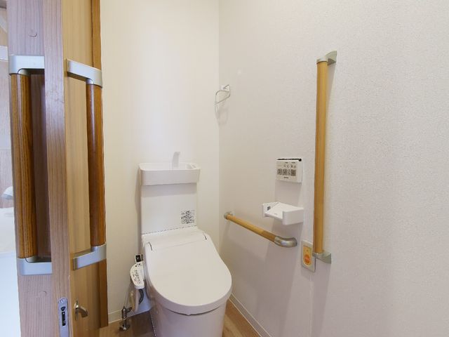 バリアフリートイレ施設 トイレ 手すり付きのトイレで、安心してご利用いただける空間を提供しています。利便性と安全性が考慮された設計です。