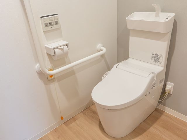 バリアフリートイレ設備 トイレ 手すり付きのモダンなトイレで、安心してご利用頂けます。利用者の自立を支える清潔な環境を整えております。
