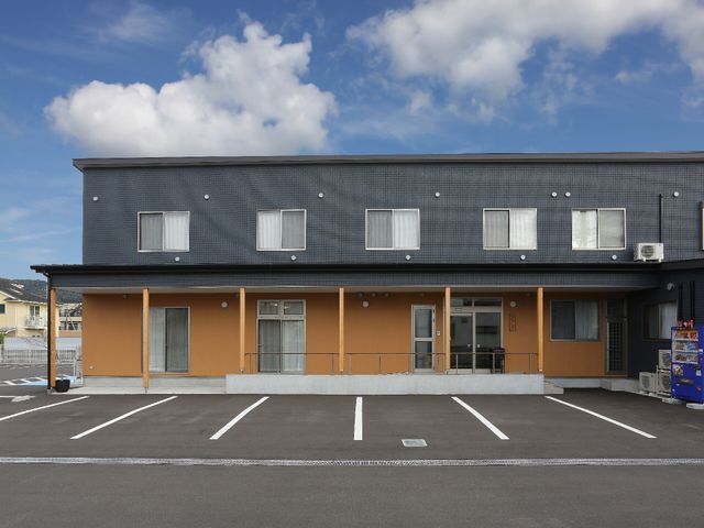 黒とオレンジの外観 外観 シンプルで清潔感のある建物です。広々とした駐車スペースがあり、来訪しやすい環境が整っています。