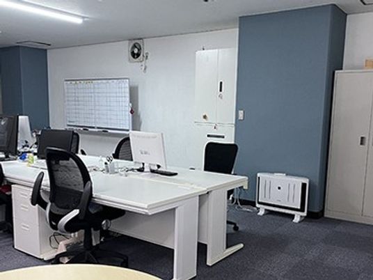 事務用の机が並ぶ部屋  