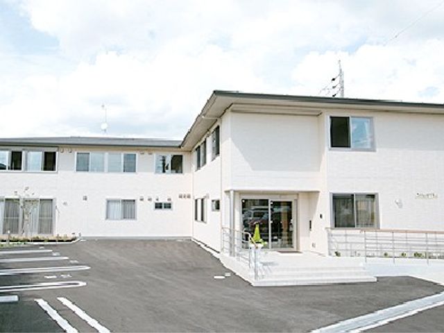 施設の外観 外観   白い外壁の建物で、玄関前にはスロープがあります。駐車スペースもあり、出入りしやすそうです。