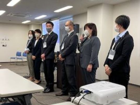スタッフが並ぶ会議室  