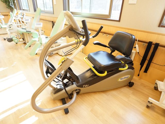 リハビリ機器が整った部屋 機能訓練室 機能訓練に必要な機器が揃った明るく広々としたスペースです。心身の健康維持に効果的な設備が整っており、快適にトレーニングを行えます。