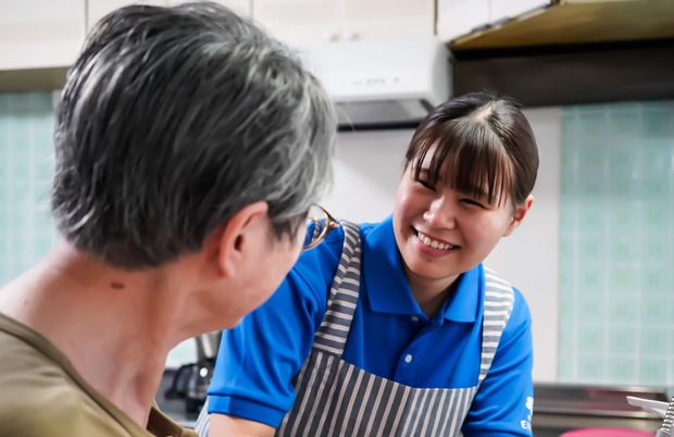 笑顔で話す職員と利用者の居室