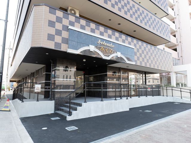 施設の入り口外観 外観 モダンな建築のエントランスです。手すり付きの階段があり、安全に気を配った設計になっています。