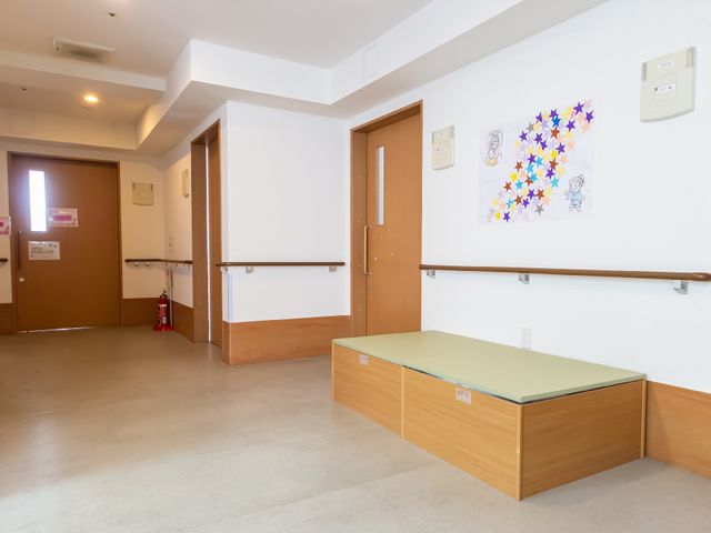 明るい廊下と掲示物 廊下 壁にはカラフルな掲示物が飾られ、温かみのある雰囲気を持つ廊下です。この場所でのお仕事は、安心感を感じながら行えるでしょう。
