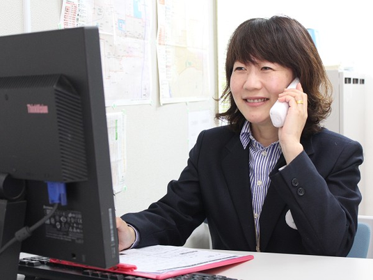 笑顔の女性が電話しているオフィス