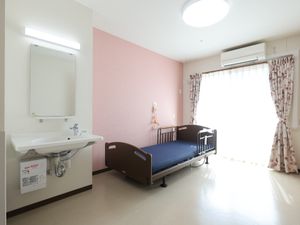 明るい個室のベッドと洗面台
