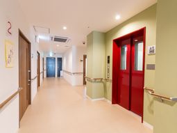 清潔な廊下と赤いエレベーター