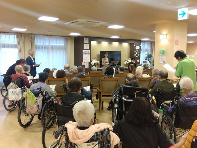 賑やかな集会の様子 多目的室 広々とした空間で、多くの方々が集まりイベントを楽しんでいます。自然光が心地よく差し込んでいます。