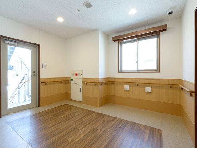 清潔な空間の廊下 ３階ホール 床がきれいに保たれた明るい通路です。こちらの通路を通じて、日々の業務や利用者様のサポートが行われます。