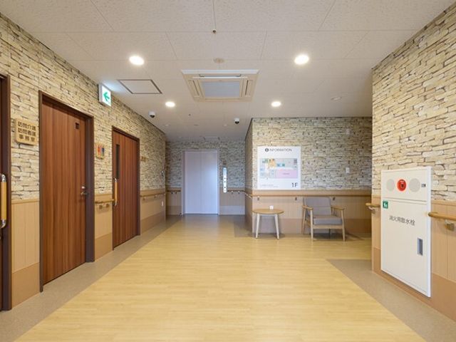 石壁と木目調のロビー エントランスホール 落ち着いた色合いのロビーは、明るく清潔感があり、待合いや交流の場としてもご利用いただけます。